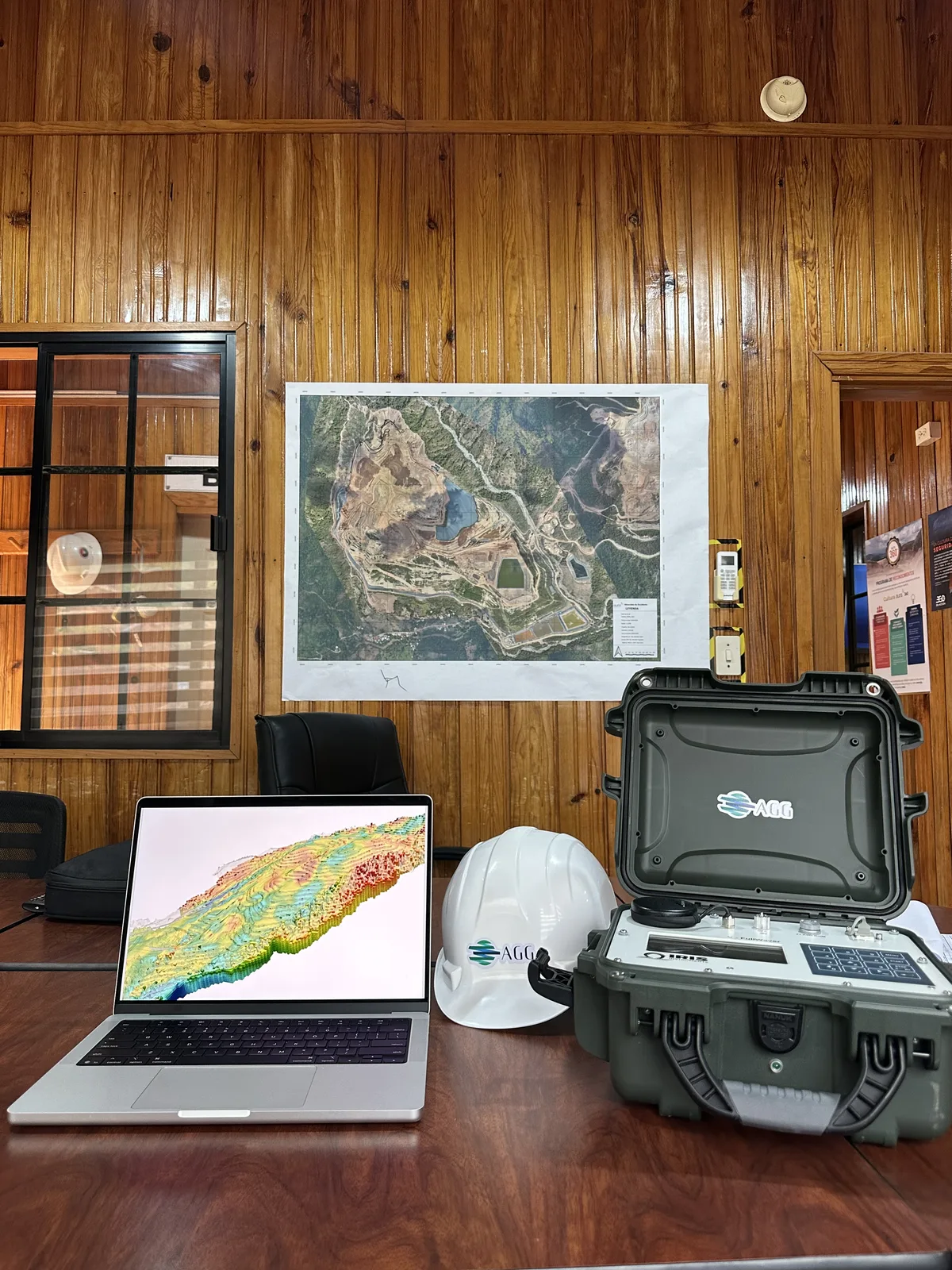 Geophysical instruments beside a laptop displaying a subsurface model